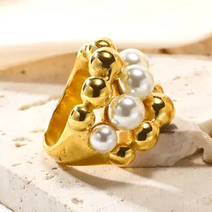 Detail of wide gold-plated titanium steel ring with stacked pearls and metal beads