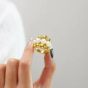 Macro detail of French style gold titanium steel ring with white pearls and beads