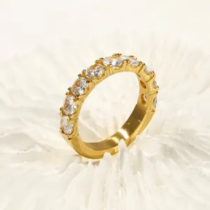 Primer plano de un anillo eternity de oro pulido con una hilera de circonitas redondas
