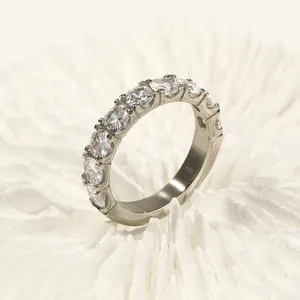 Anillo eternity de plata pulida con once piedras brillantes sobre coral blanco