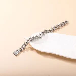 Silbernes Panzerarmband mit Zirkon-Steinen auf weißer dekorativer Blattschale