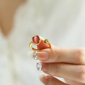 Close-up of elegant gold cat-eye stone ring with floral details on adjustable band