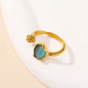 Detailed macro view of an adjustable gold ring featuring an oval blue opal stone and beads