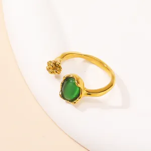 Detailed view of adjustable gold ring with green cat eye stone and floral gold accents
