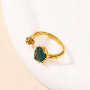 Detail of adjustable gold ring featuring an oval green cat-eye stone and beaded texture