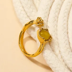 Macro detail of adjustable gold ring featuring a green cat eye stone and a cute cat paw