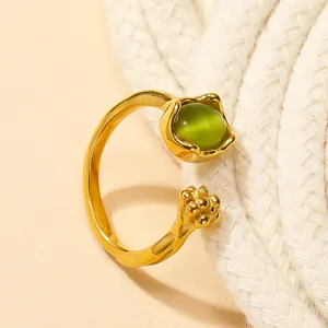 Macro detail of golden cat claw ring with green cat eye stone and flower bud setting