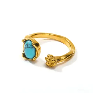 Adjustable gold ring with turquoise stone and textured bead detail on white background