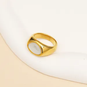 Detail van minimalistische gouden ring met een ovale witte marmeren steen inleg