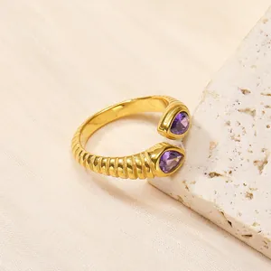Vue détaillée de la bague dorée nervurée avec pierres de zircon violettes en goutte