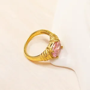 Dettaglio dell'anello vintage in titanio dorato con zircone rosa e texture a coste
