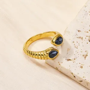 Détail d'une bague dorée vintage avec zircon bleu taille poire et texture spirale