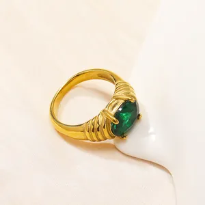 Anello vintage in titanio dorato con zircone verde ovale e fascia a trama intrecciata