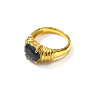 Anello vintage dorato con gemma nera ovale e fascia strutturata su sfondo bianco