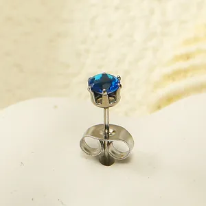 Gros plan d'un clou d'oreille couronne avec zircon bleu et serti à six griffes en acier