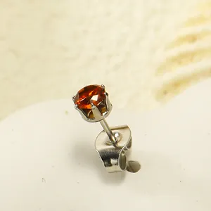 Macro d'une boucle d'oreille couronne à six griffes avec un zircon ambré facetté