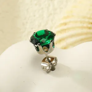 Gros plan sur un clou d'oreille couronne en argent avec zircone vert émeraude
