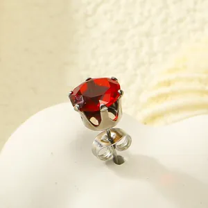 Vue macro d'une boucle d'oreille couronne en argent avec une grosse pierre de zircon rouge