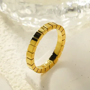 Vista macro de anillo geométrico de cubitos dorados con acabado en acero inoxidable