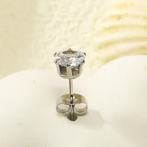 Gros plan d'une boucle d'oreille couronne en acier avec zircon sur un support en cœur
