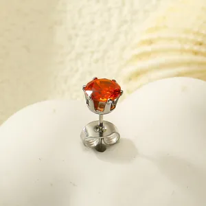 Vue macro de boucles d'oreilles en acier avec zircon orange brillant et serti à six griffes