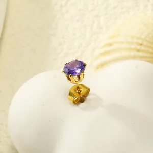 Gros plan sur boucle d'oreille zircone violette avec monture couronne dorée