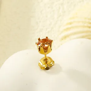 Détail d'une boucle d'oreille couronne dorée avec zircone ambre et fermoir papillon