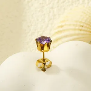 Vue détaillée de la boucle d'oreille couronne dorée avec zircon violet brillant
