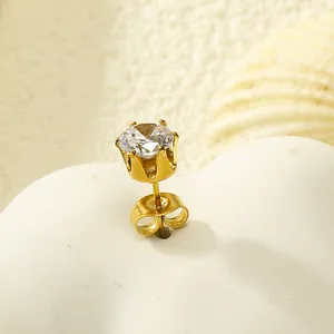 Vue détaillée d'une boucle d'oreille couronne dorée avec zircon rond et six griffes