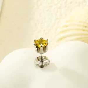 Vue macro de la boucle d'oreille zircon jaune avec monture couronne en métal argenté