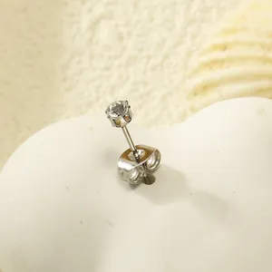 Détail macro d'une boucle d'oreille en acier inoxydable avec une pierre en zircone ronde