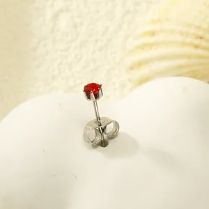 Vue détaillée d'une boucle d'oreille en zircon rouge avec serti à six griffes sur socle