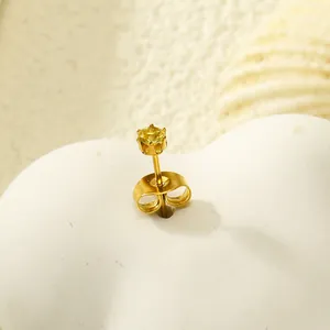 Gros plan sur un clou d'oreille couronne en acier doré avec un zircon jaune brillant