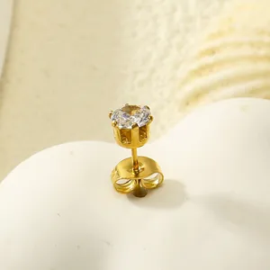 Vue macro d'une boucle d'oreille couronne dorée à six griffes avec zircone ronde