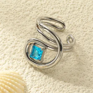 Makroaufnahme des geschwungenen Silberrings mit quadratischem blauem Stein auf Stein