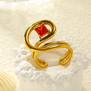 Makroaufnahme eines 18k vergoldeten S-förmigen Rings mit quadratischem rotem Zirkonia
