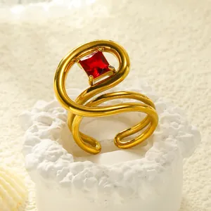 Detailansicht eines gebogenen 18k vergoldeten Rings mit quadratischem rotem Zirkonia