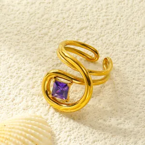 Makroaufnahme eines vergoldeten Rings mit quadratischem lila Zirkon und Wellendesign