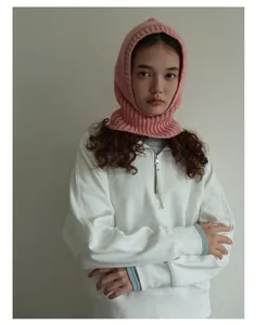 Detalle del pasamontañas de lana rosa combinado con una sudadera blanca con cremallera