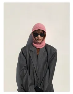 Detalle del pasamontañas rosa de lana usado por una modelo con una chaqueta gris