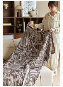 Detail of Nordic jacquard knit blanket with brown and cream leaf pattern texture