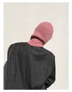 Vista trasera de modelo con pasamontañas de punto rosa y una chaqueta de cuadros