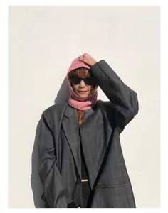 Pasamontañas de lana rosa combinado con una chaqueta blazer de cuadros grises