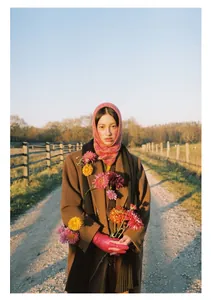 Detail of pink floral knitted balaclava hood with brown coat and rustic winter styling