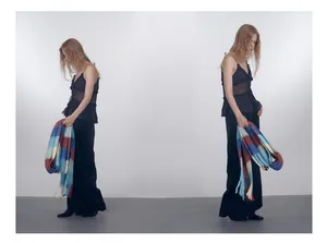 Detailed view of long tasseled scarf with blue and red gradient plaid on model