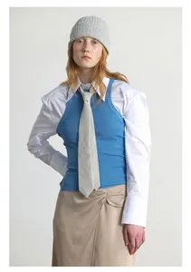 Detailansicht eines Winteroutfits mit blauer Strickweste, grauer Mütze und Hemd