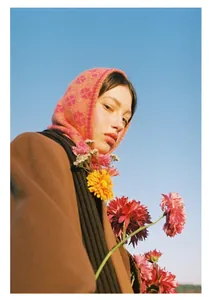 Close-up of pink clover jacquard knit balaclava hood worn with winter coat and scarf