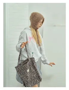 Close-up of leopard print canvas tote bag featuring a textured pattern and a woven tag