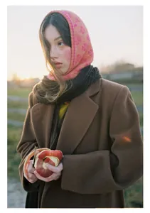 Close-up of pink clover jacquard knit balaclava styled with a brown wool coat and scarf