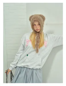 Detail of brown faux fur bear ear beanie with colorful accents and long earflaps